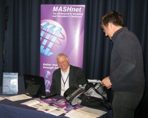 Brian Dangerfield responds to a delegate at the MASHnet stand